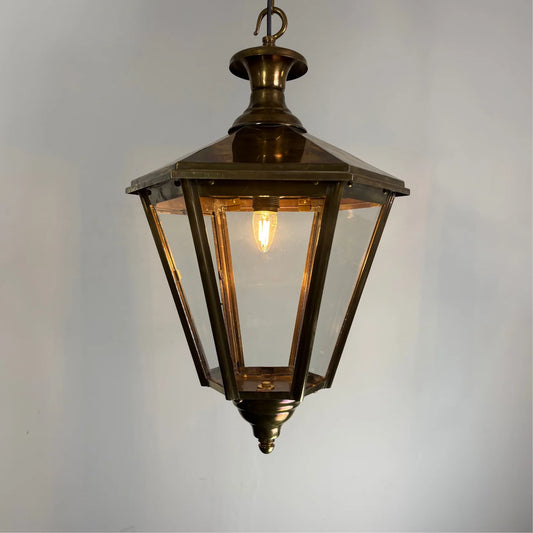 Distress brass Fitzwilliam hexagonal pendant light by Kansa hanging from ceiling, featuring geometric hexagon shape and warm brass finish.
