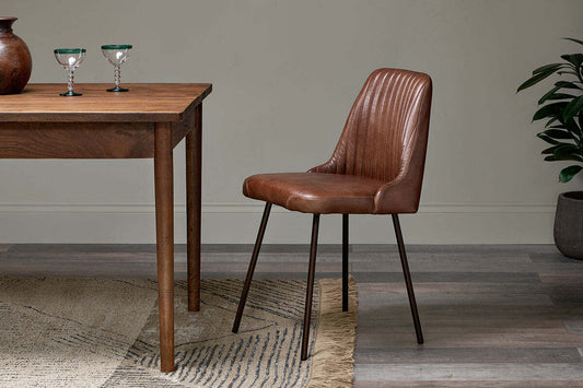 Chocolate brown Harsha leather dining chair by Nkuku, featuring a stylish and comfortable design for modern dining rooms.