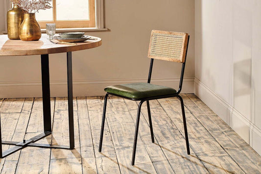 Green Nkuku Iswa leather and cane dining chair with a modern design, showcasing its woven cane back and leather seat.