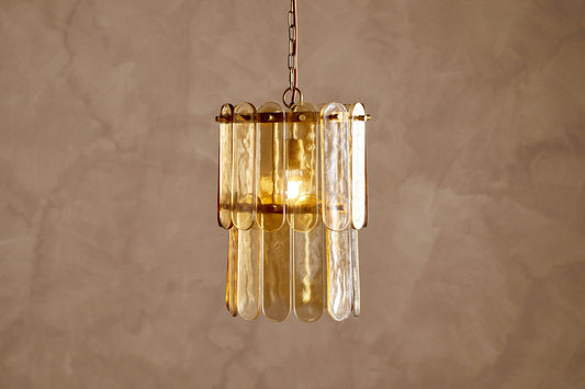 Nkuku Itan recycled glass tiered pendant light in amber, showcasing its layered glass design and warm glow.