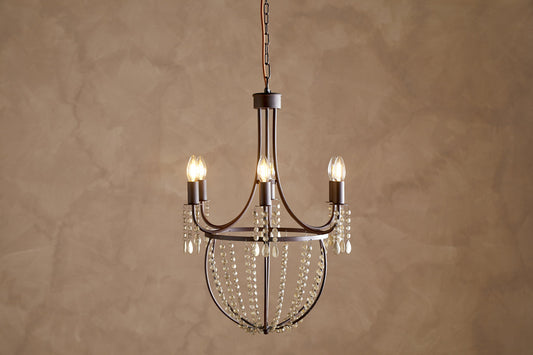 Naavia rustic iron and crystal chandelier by Nkuku featuring a rust finish and intricate crystal details.